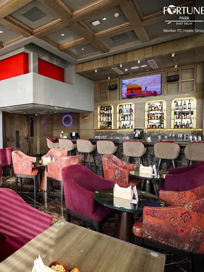 The inviting interior of Neptune Bar & Lounge, with its plush, colorful seating and fully stocked bar, creates a sophisticated atmosphere for our guests.