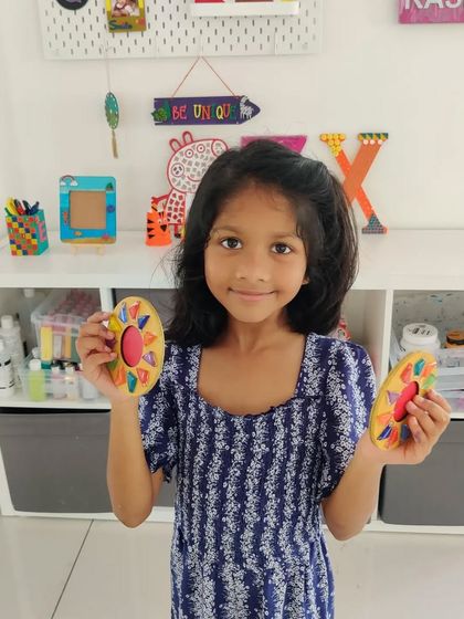 This young artist is happy to display the two mosaic T-light holders she made for Diwali.