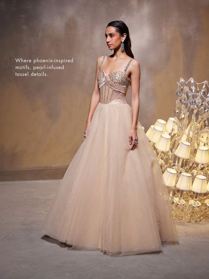 The Bella Gown, where phoenix-inspired motifs and pearl-infused tassel details adorn the exquisite corset, blending artistry with a breathtaking silhouette.