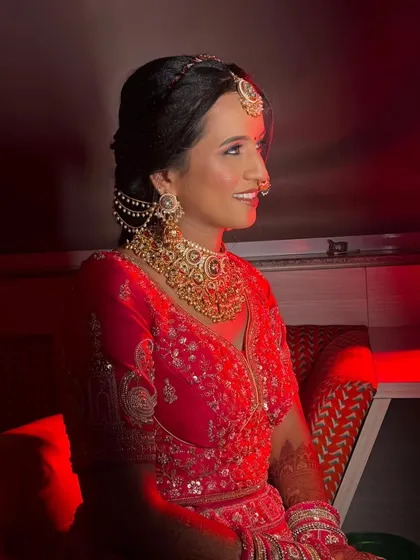A profile shot under dramatic lighting. This angle showcases the flawless blending of her makeup and the elegant side-swept hairstyle, creating a look that is both modern and timeless.