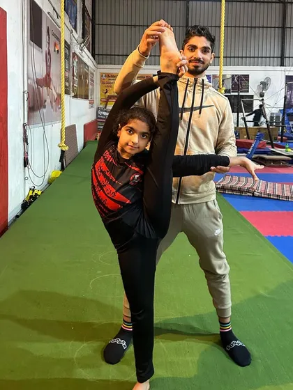 Discipline and flexibility start early. We coach students of all ages, focusing on proper form for skills like the standing split to build a strong foundation for future gymnastic development.