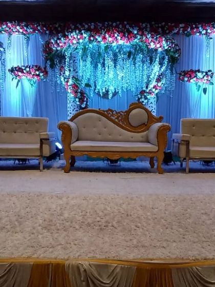 A simple yet elegant stage setup with a beautiful floral arrangement and classic seating. This shows how we can create a beautiful focal point even with a more minimalist design.