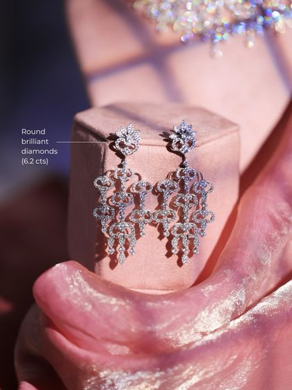 The matching Pave Diamond Bridal Earrings, featuring 6.2 carats of round brilliant diamonds. Their chandelier design offers subtle luxury and a glow that is truly unforgettable.