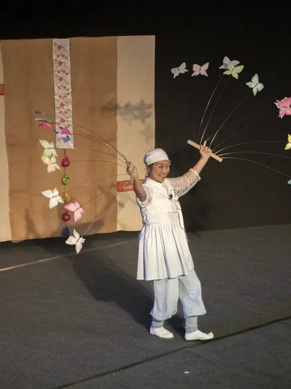 A performer from Korea's 'Puppet Fantasy' creates a beautiful spectacle with butterfly puppets on flexible rods. This show blends puppetry, music, dance, and mime to celebrate Korean cultural heritage.