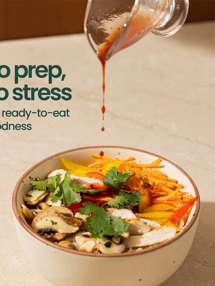 No prep, no stress, just ready-to-eat goodness. This image of a beautiful salad bowl with dressing being poured on top perfectly captures the ease and elegance of our meals.