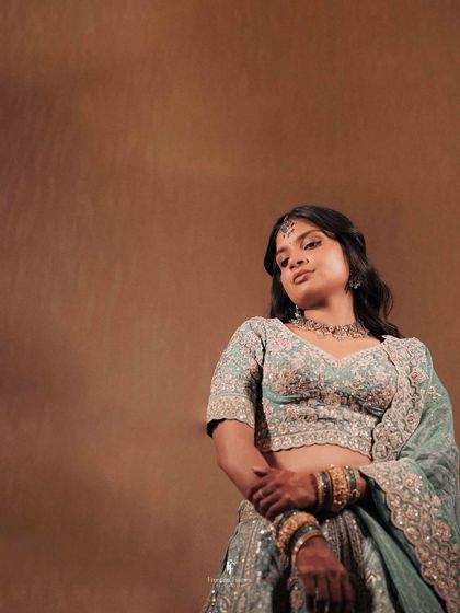 A portrait of the bride in a stunning light blue lehenga, capturing her grace and beauty. This is a perfect example of a timeless bridal portrait.