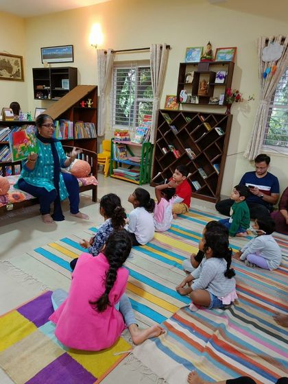 The storyteller shows a picture from the book, her expression conveying the drama of the scene.