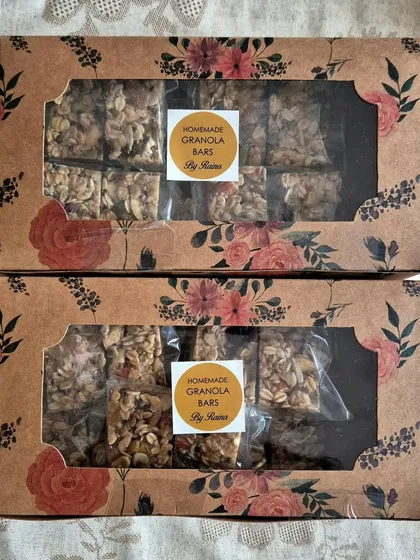 Two gift boxes of my homemade Granola Bars. These energy bars are packed with rolled oats, nuts, seeds, and dried fruits, making them a perfect healthy snack.