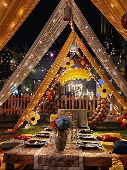 I create cozy and intimate celebrations too. This beautiful outdoor birthday setup features a low seating arrangement with comfortable cushions under a canopy of sheer yellow and white drapes, all lit up with magical fairy lights for a perfect evening party.