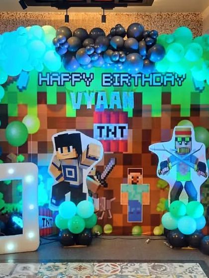 A Minecraft-themed 10th birthday party. We used a pixelated backdrop, life-sized character cutouts from the game, and a green and black balloon arch to recreate the world of Minecraft.