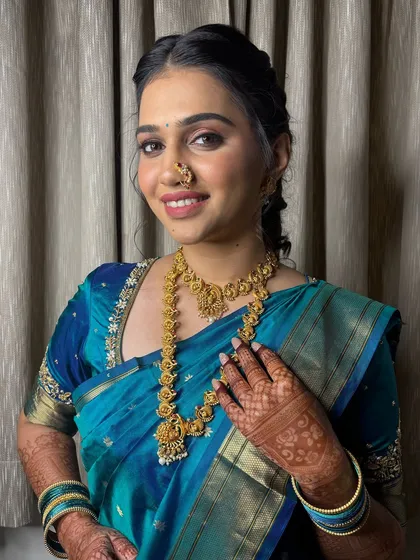 A happy bride, showing off her intricate henna and beautiful gold jewellery.