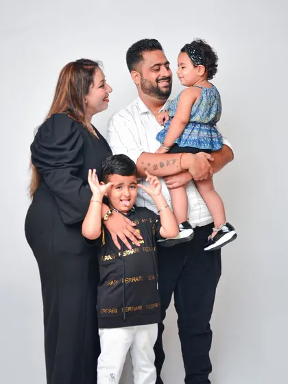 A fun and candid family photo that captures the real-life energy of a family with young children. We love these unposed moments that show off everyone's playful side.