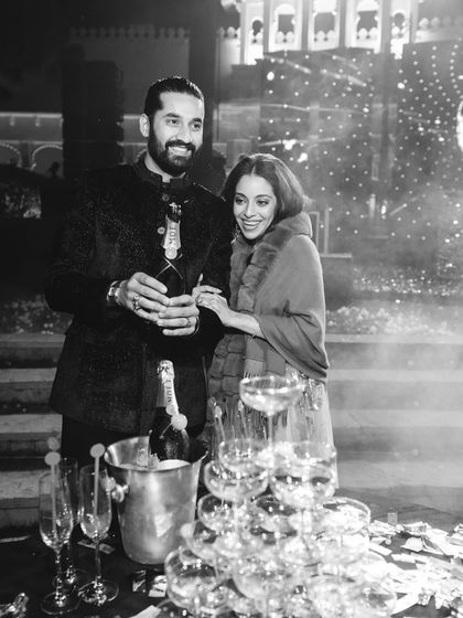 The happy couple enjoying a champagne tower moment at their disco-themed celebration.
