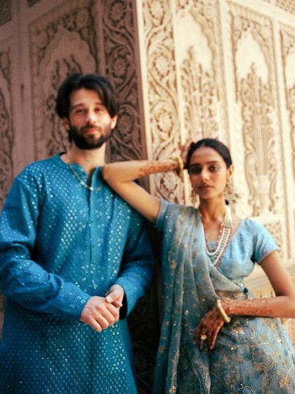 A portrait that feels both confident and connected. The bride's relaxed pose against the groom, set against a beautifully detailed wall, creates a modern yet timeless image. This is about capturing your individual personalities as well as your shared bond.
