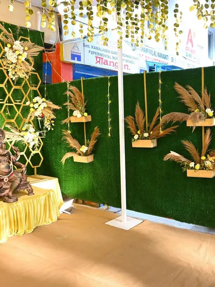 A unique decor wall combining a green turf backdrop with modern hexagonal patterns and dried pampas grass arrangements.