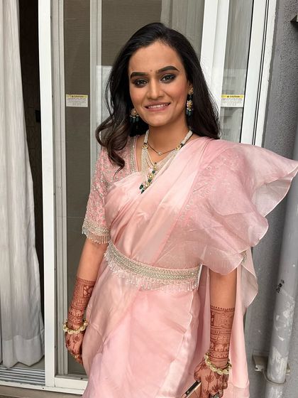 A beautiful reception look in a simple and elegant organza saree. The makeup is focused on a smokey eye to add a touch of glamour.