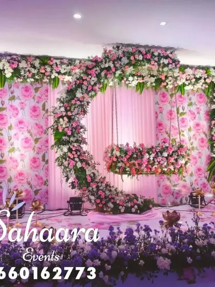 For a truly special naming ceremony or baby shower, we designed this breathtaking floral swing. The crescent moon shape, covered in soft pink and white flowers against a rose-patterned backdrop, creates a magical setting to welcome your little one.