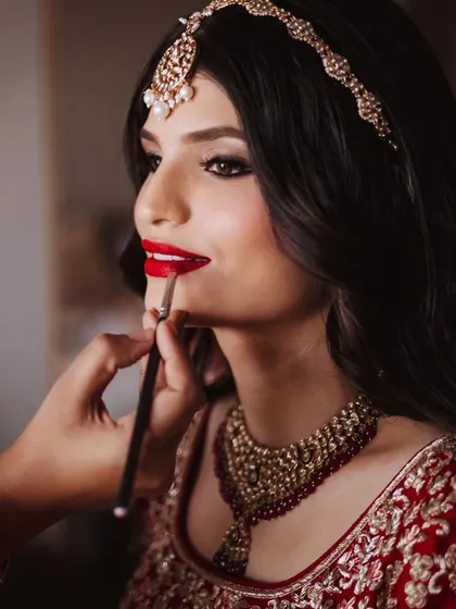 The final touch for a classic bridal look. A perfectly defined red lip is timeless. Here, I'm using a brush for precise application, ensuring the color is rich and lasts through all the wedding day emotions.