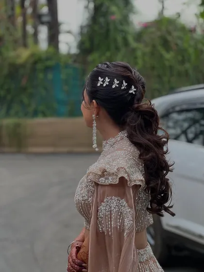A hairstyle can define your entire look. For this Sangeet, we chose a chic and modern voluminous ponytail, accented with delicate butterfly clips. It's a fun, elegant, and practical choice that keeps the hair off the face for a night of dancing.