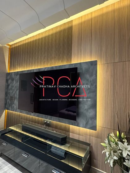 A closer look at the TV panel, showing the contrast between the warm, louvered wood and the cool, stone-patterned surface, all framed by soft backlighting.