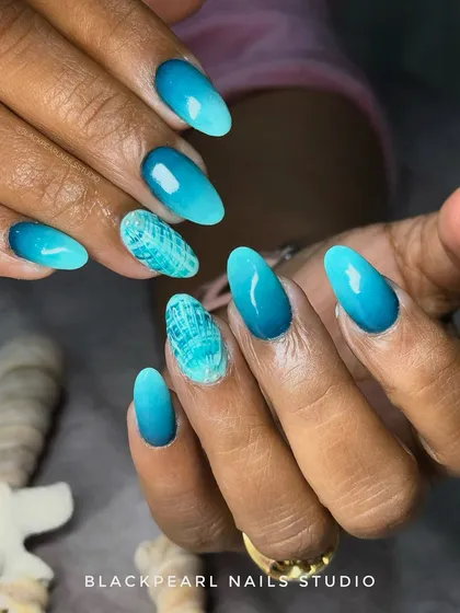 For a client's beach vacation, I created these ocean-inspired ombré nails. The design features a gradient of blue and turquoise shades to mimic the sea, with a textured shell effect on the accent nail for a truly thematic look. This shows my ability to create custom, imaginative nail art for any occasion.