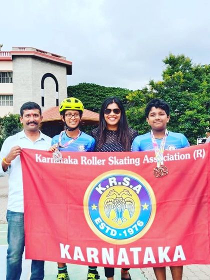 Proudly holding the Karnataka Roller Skating Association flag with my skaters after their win at the national inter-district championship. We represent our state with pride.
