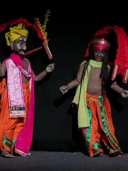 Two dancing marionettes in vibrant traditional costumes from the Sri Lankan show. The performance is a celebration of dance, music, and colour.