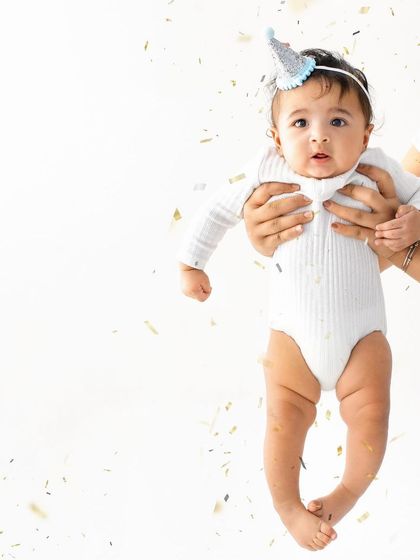Up in the air! A shower of confetti and a tiny party hat make this a fun and celebratory shot for a six month milestone. The genuine look of wonder on his face is priceless.
