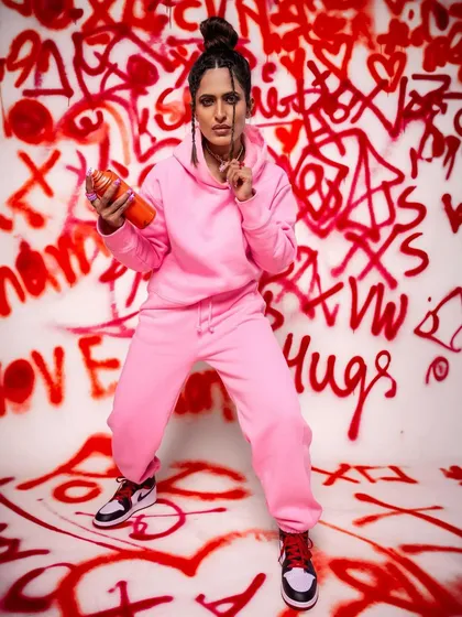 A bold and energetic pose against our custom graffiti wall. This setup is perfect for streetwear brands, hip-hop concepts, or anyone wanting a vibrant, urban feel for their shoot.
