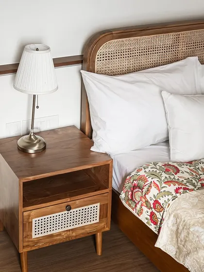 My teak wood side table, sculpted from nature’s finest material. The design includes an open shelf and a drawer with a rattan front, offering both beauty and functionality.