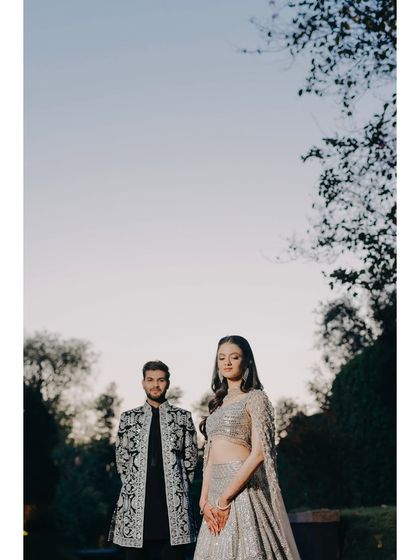 A regal portrait set against a lush, green backdrop. The couple's coordinated outfits and poised stances exude elegance, showcasing our ability to create classic and timeless engagement photographs.