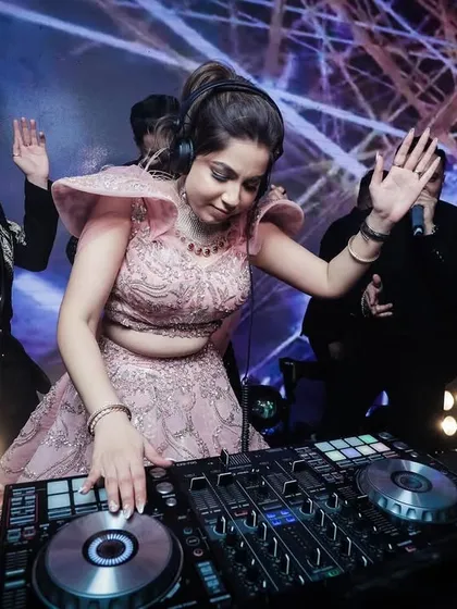 The bride takes a turn at the DJ console, a fun and unique moment from the cocktail party.