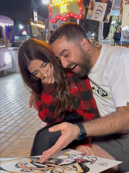 The reaction is everything! This couple's laughter upon seeing their caricature is the best feedback an artist can get.
