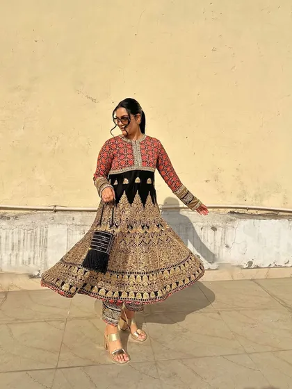 The twirl of this gorgeous Anarkali shows how the black tassel potli moves with you. It's a chic and modern accessory for a grand traditional outfit.