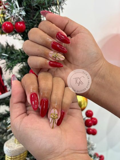 A full view of the classic red and gold bow Christmas nail set. It's a timeless and elegant choice for the holiday season.
