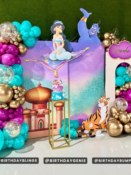 This angle of the Aladdin setup highlights the glitter-filled balloons and the golden plinth for the cake.