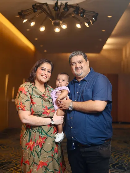 A classic family portrait with both parents and their baby. This is a great example of a posed shot that still feels warm and natural.