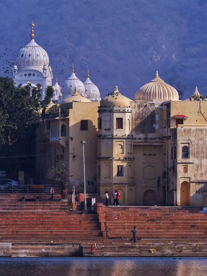 The ghats and temples of Pushkar under a soft, hazy light. The scene is full of a quiet noise, a silent hum of devotion and history that is deeply felt.