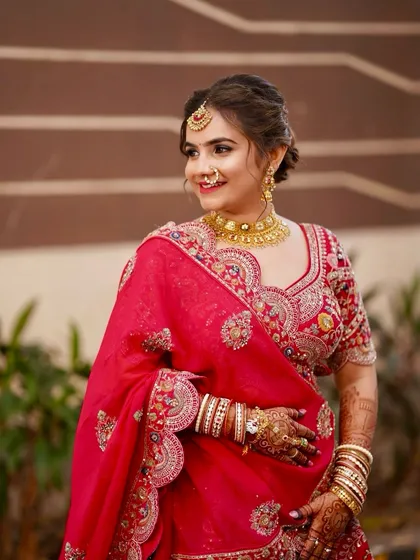 A beautiful profile of the bride in her red lehenga. The makeup is subtle yet defining, perfect for a classic bridal look.
