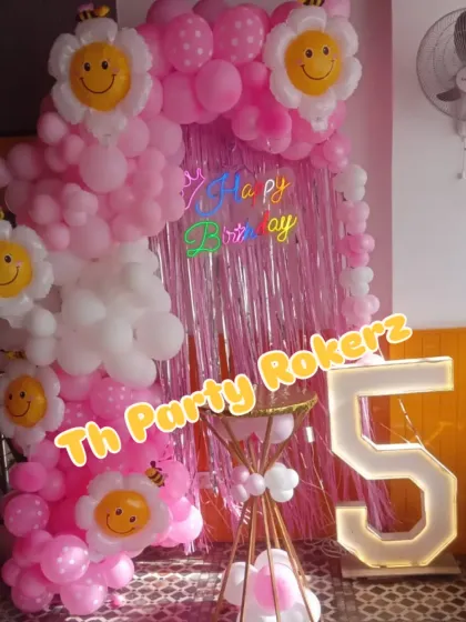 Another angle of the smiley flower theme, showing the pink shimmer backdrop and the unique conical cake stand.