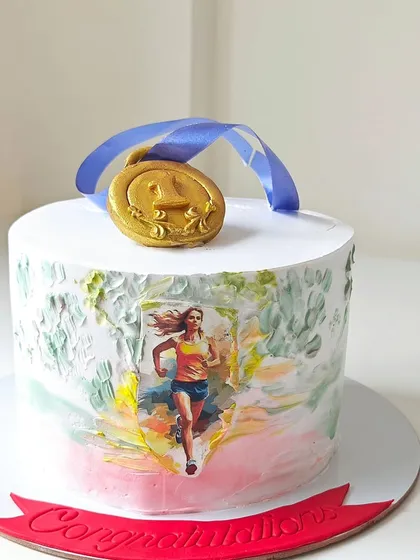 A cake to celebrate a runner's achievement, featuring an edible image of a marathon runner and topped with a gold medal. The palette-knife texture on the side adds an artistic touch.