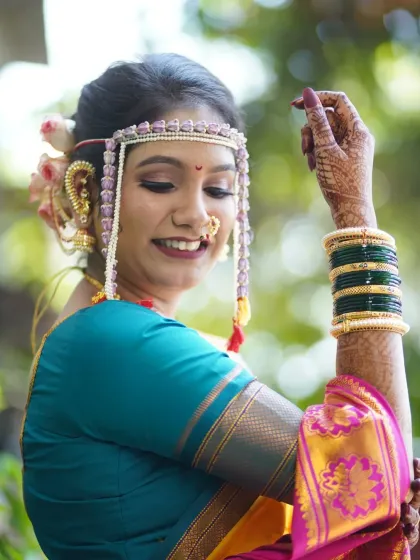 Another artistic pose, highlighting the bride's joy and the intricate details of her look, from her mehndi to her mundavalya.