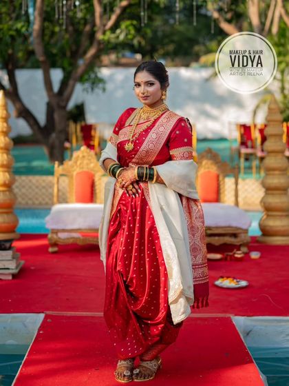 A full-length shot of Priya in her perfectly draped red Nauvari saree, showcasing the complete traditional Maharashtrian bridal look.