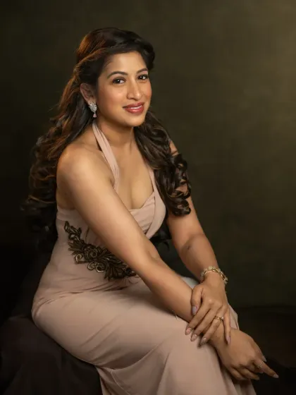 This portrait of Pallavi showcases a bright, confident smile. The lighting is crafted to highlight her features and the elegant lines of her dress, capturing a moment of pure joy and self-celebration during her 40th birthday shoot.