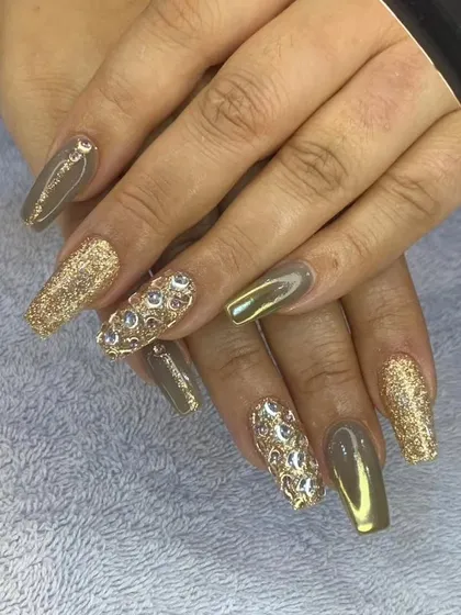 This luxurious set features coffin-shaped nails with a mix of gold chrome, gold glitter, and nails fully encrusted with gold crystals. It's a bold and opulent design.