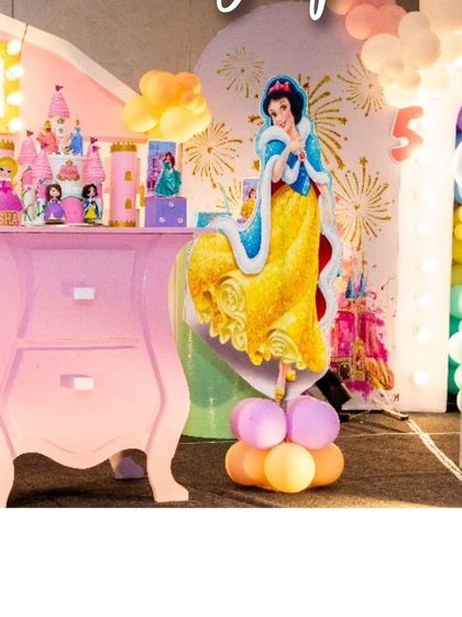 A beautiful Snow White cutout stands next to a pink dresser used for displaying desserts. I love mixing different character elements to create a rich and varied princess theme.