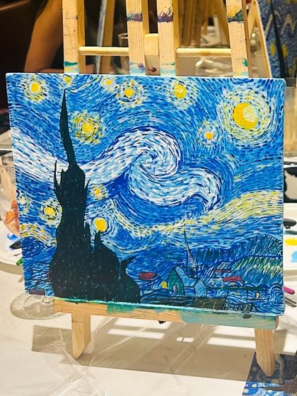 A beautifully detailed 'Starry Night' painting on an easel, showcasing the intricate swirls and colors achieved with knife painting.