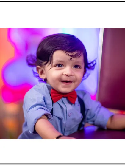 A happy little gentleman dressed in a bowtie and suspenders for his studio photoshoot. I have a variety of cute outfits and accessories available.
