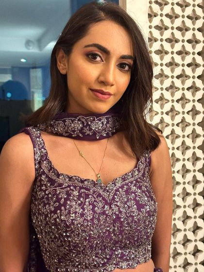 A portrait showing the full effect of the sangeet makeup. The pink eyeshadow makes her eyes pop.