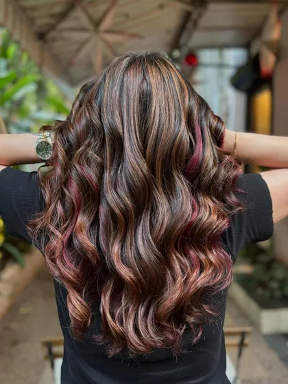 A rich brunette balayage with a little surprise. I wove in a few peekaboo strands of magenta for a playful pop of color that's still subtle.